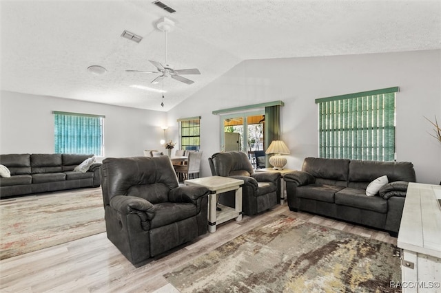 living room featuring ceiling fan, lofted ceiling, a textured ceiling, and light hardwood / wood-style flooring