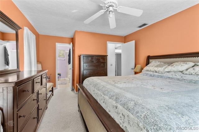 carpeted bedroom with connected bathroom, ceiling fan, and a textured ceiling