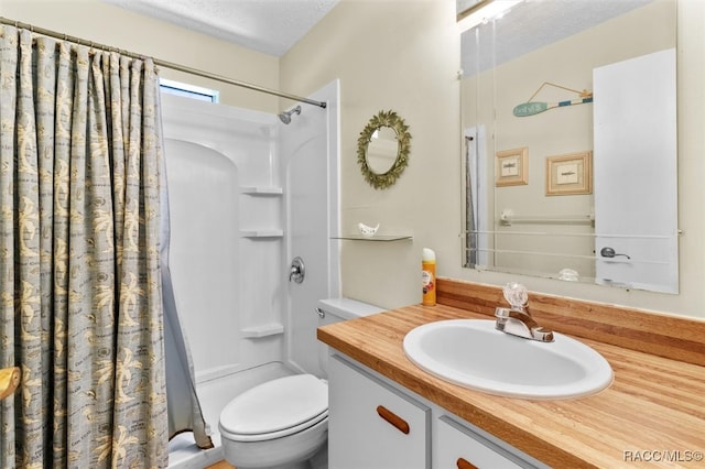 bathroom featuring vanity, a textured ceiling, toilet, and walk in shower