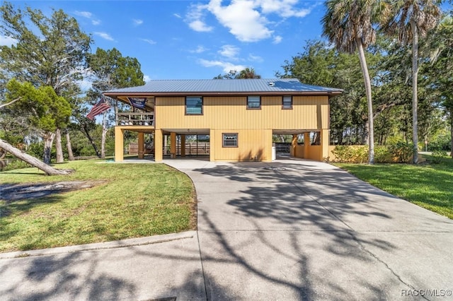 view of front of house with a carport and a front lawn