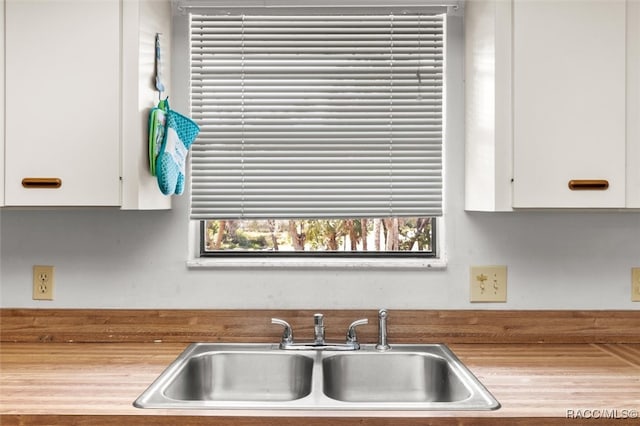 kitchen with a healthy amount of sunlight, white cabinetry, and sink