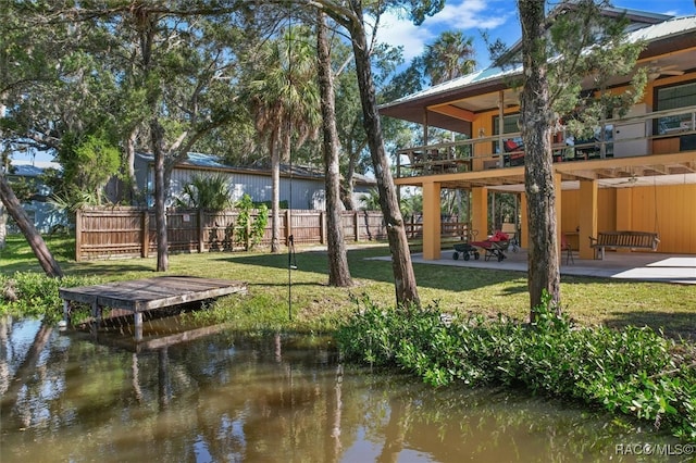 exterior space with a patio, a water view, a balcony, and a lawn