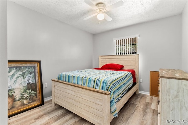 bedroom featuring ceiling fan, wood-type flooring, and a textured ceiling