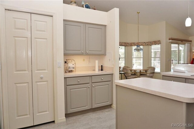3033 N Chandler Dr, Hernando, FL 34442 - kitchen featuring gray cabinetry, light countertops, light wood-style flooring, pendant lighting, and a chandelier