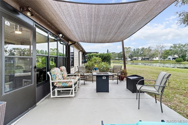 view of patio with an outdoor living space with a fire pit