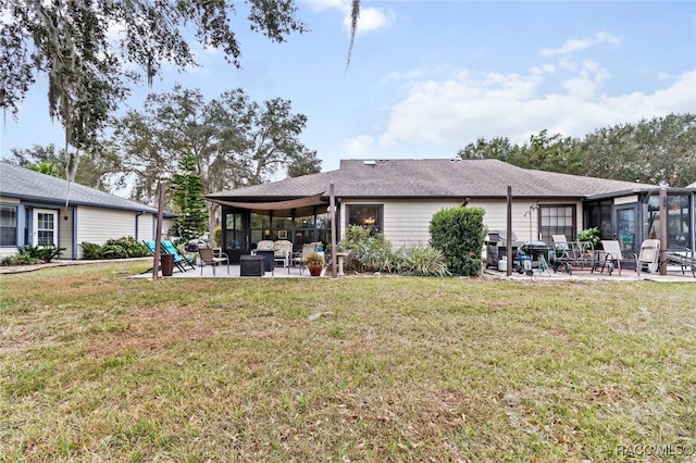 rear view of house featuring a lawn, an outdoor living space, a patio, and a sunroom