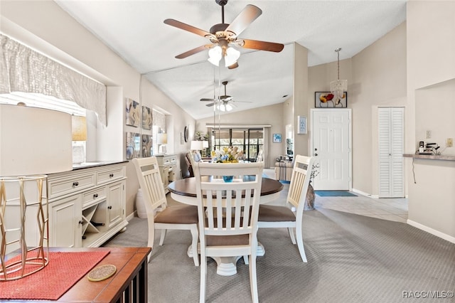 dining area featuring ceiling fan, light colored carpet, and vaulted ceiling