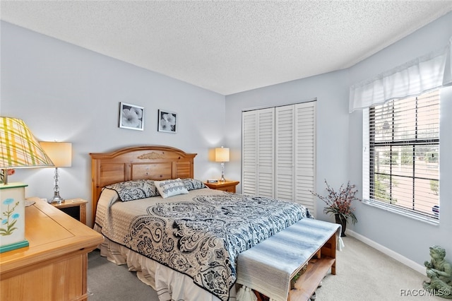 bedroom featuring a textured ceiling, light colored carpet, and a closet