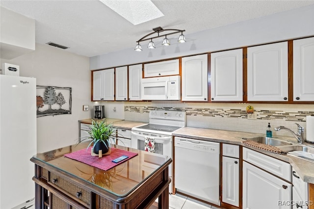 kitchen featuring a skylight, a textured ceiling, white appliances, sink, and white cabinetry