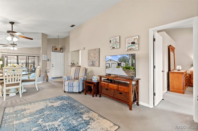 carpeted living room featuring a textured ceiling, high vaulted ceiling, and ceiling fan