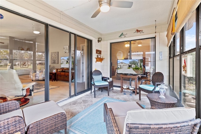 sunroom featuring ceiling fan