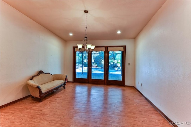 interior space with french doors, an inviting chandelier, and light wood-type flooring