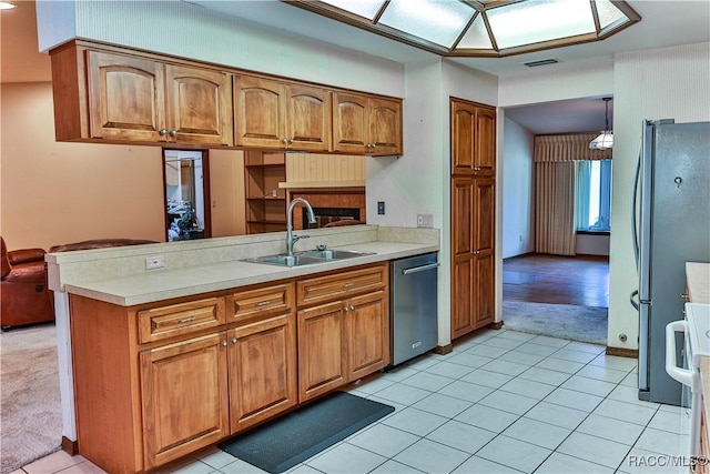 kitchen with sink, kitchen peninsula, pendant lighting, light carpet, and appliances with stainless steel finishes