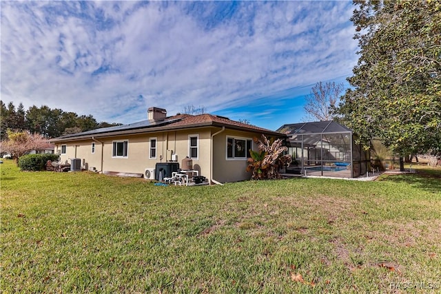 rear view of property with glass enclosure, a lawn, and central air condition unit