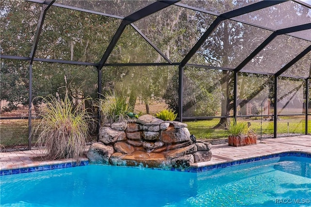 view of swimming pool featuring pool water feature and a lanai