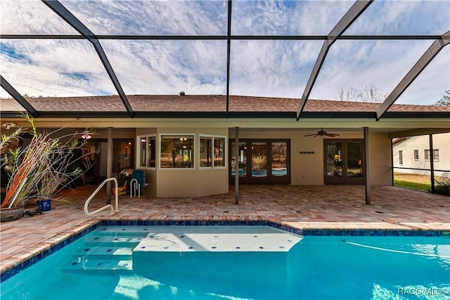 view of swimming pool featuring glass enclosure, ceiling fan, and a patio