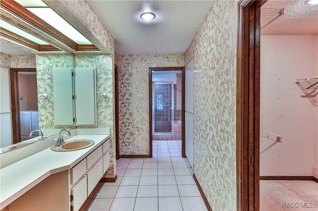 bathroom featuring tile patterned flooring, vanity, and a textured ceiling