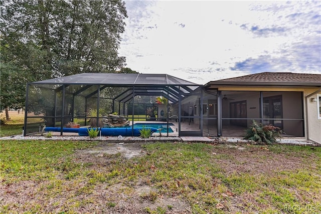 view of yard featuring glass enclosure and ceiling fan