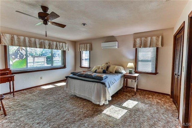 carpeted bedroom with a wall mounted air conditioner, ceiling fan, and a closet