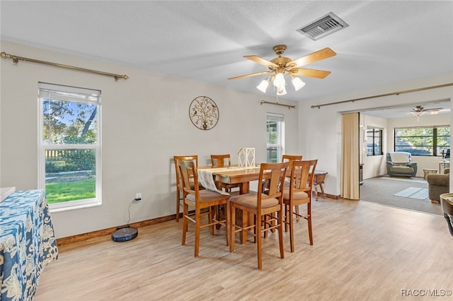 dining room with ceiling fan and light hardwood / wood-style flooring