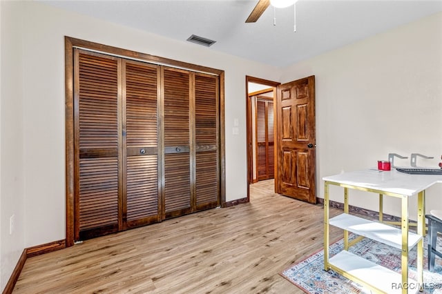 bedroom with ceiling fan, a closet, and light hardwood / wood-style flooring