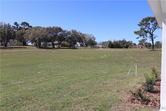 view of yard featuring fence and a rural view