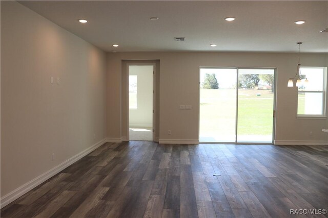 spare room with recessed lighting, visible vents, dark wood finished floors, and baseboards