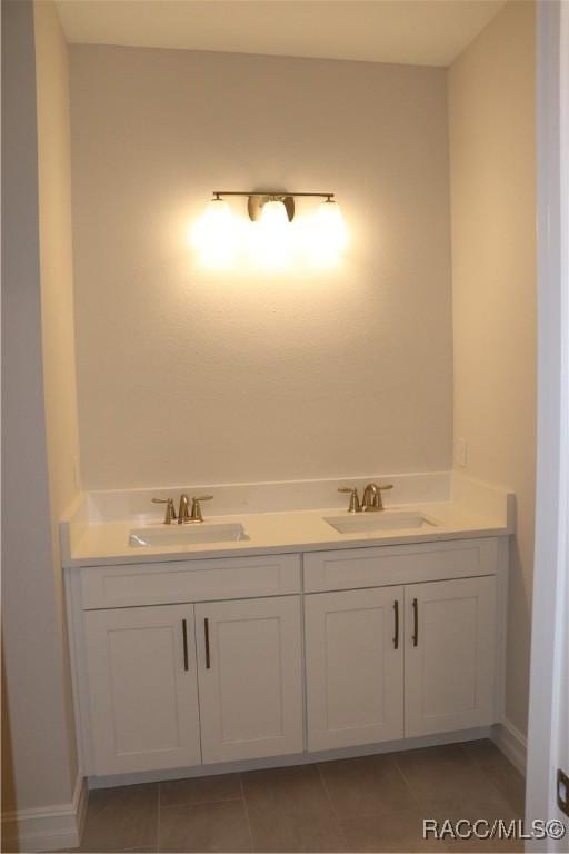 bathroom featuring double vanity, a sink, and tile patterned floors