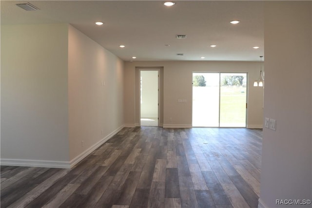 unfurnished room with baseboards, dark wood-style flooring, visible vents, and recessed lighting