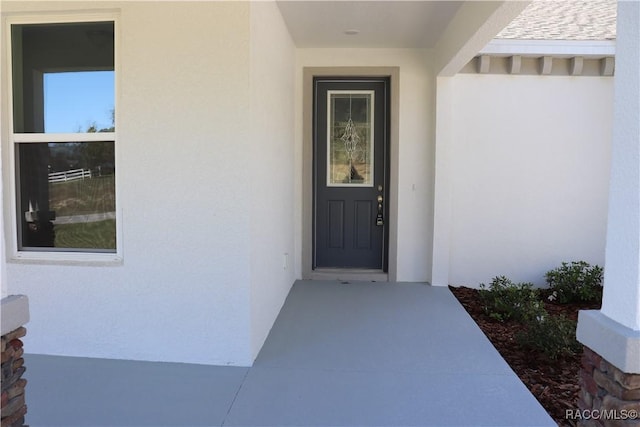 entrance to property with stucco siding