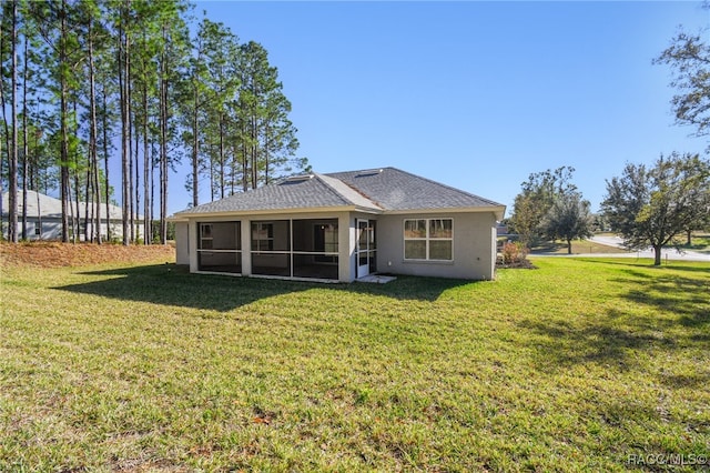 rear view of house featuring a lawn and a sunroom