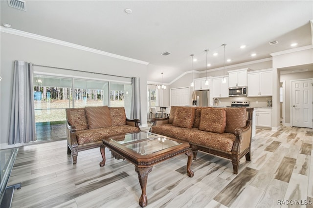 living room with a notable chandelier, lofted ceiling, ornamental molding, and light hardwood / wood-style flooring