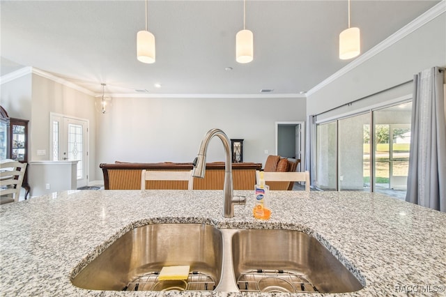 kitchen featuring pendant lighting, ornamental molding, and sink