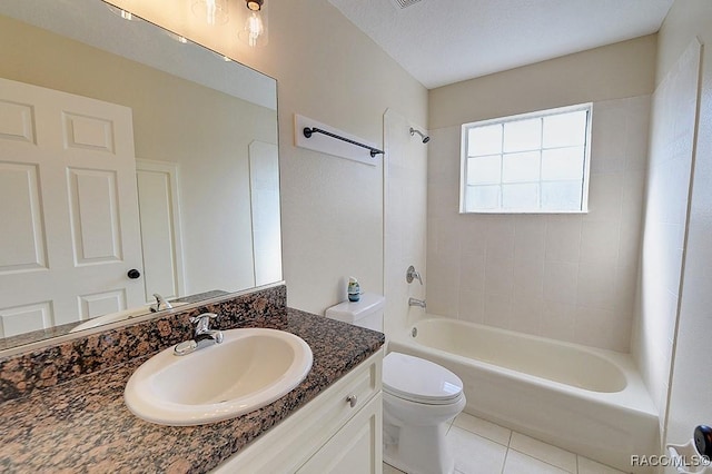 full bathroom featuring toilet, tiled shower / bath combo, tile patterned flooring, a textured ceiling, and vanity