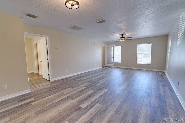 spare room with a textured ceiling, ceiling fan, and hardwood / wood-style flooring