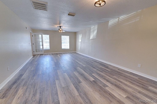 empty room with ceiling fan, dark hardwood / wood-style flooring, and a textured ceiling