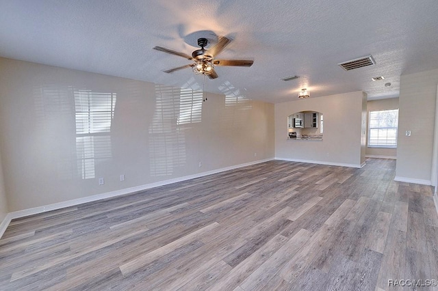 spare room with ceiling fan, wood-type flooring, and a textured ceiling