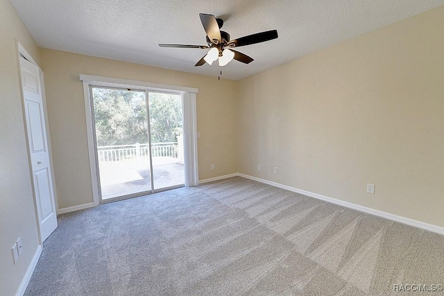 carpeted empty room with ceiling fan and a textured ceiling