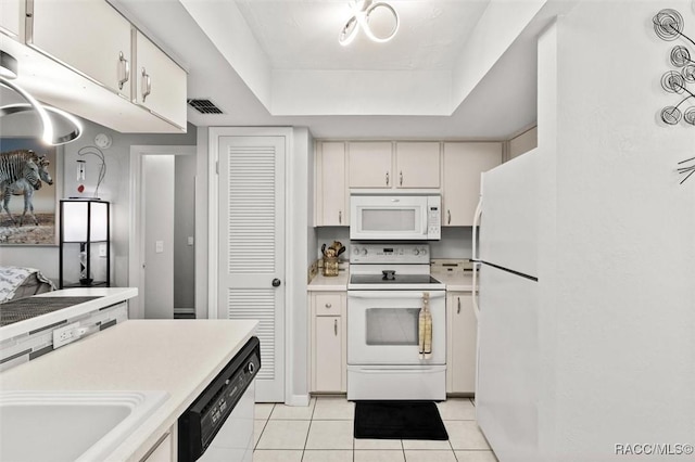 1631 N Dalary Pt, Crystal River, FL 34429 - kitchen featuring white appliances, light tile patterned flooring, light countertops, a tray ceiling, and white cabinets