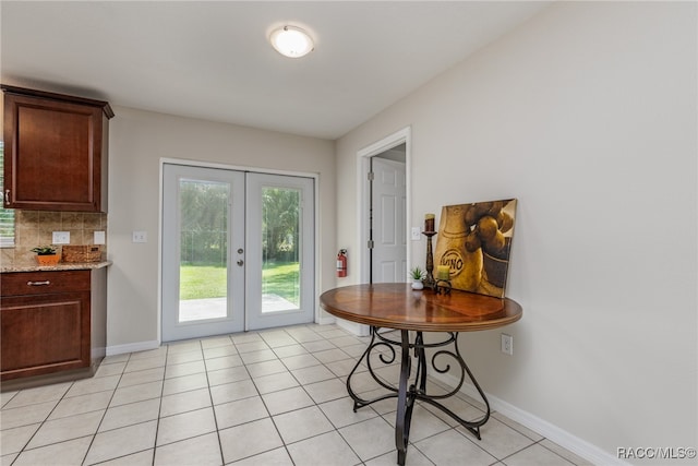 entryway with light tile patterned flooring and french doors