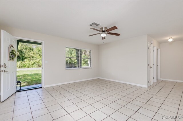 empty room with ceiling fan, a healthy amount of sunlight, and light tile patterned flooring