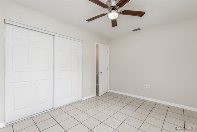 unfurnished bedroom featuring light tile patterned flooring, a closet, and ceiling fan