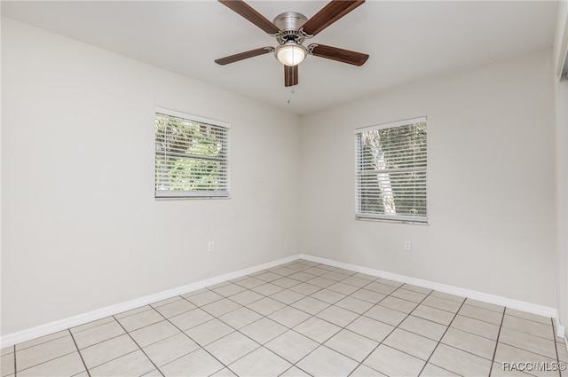 tiled empty room featuring ceiling fan and a wealth of natural light