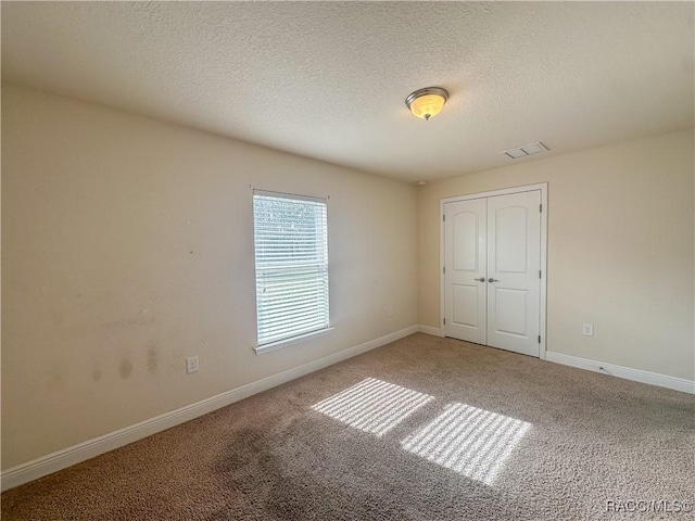 unfurnished bedroom featuring carpet, a closet, and a textured ceiling