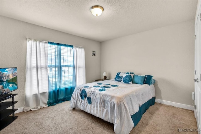 bedroom featuring light colored carpet and a textured ceiling