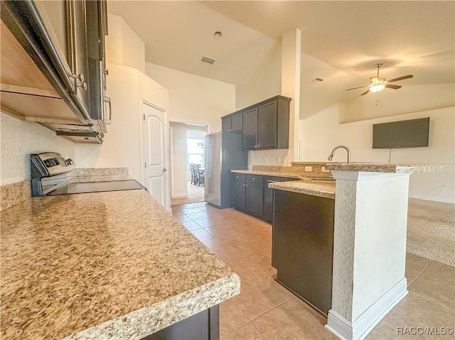 kitchen with visible vents, range with electric cooktop, freestanding refrigerator, a peninsula, and light countertops