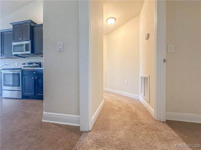 hallway with baseboards, visible vents, and a textured ceiling