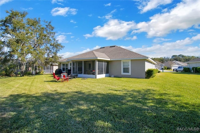 back of property with a lawn and a sunroom