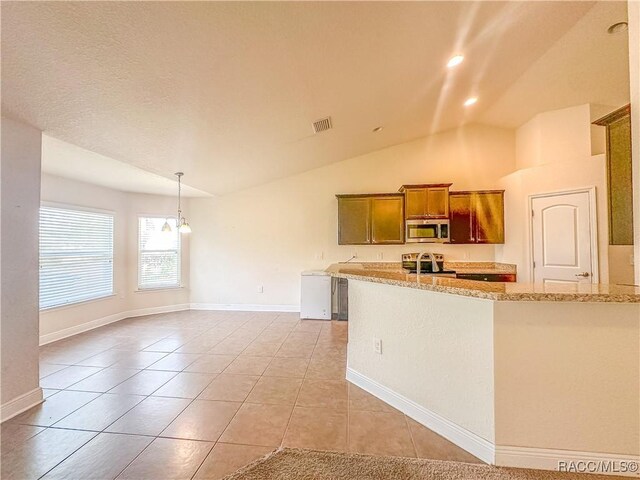 kitchen with light stone counters, light tile patterned flooring, kitchen peninsula, and appliances with stainless steel finishes