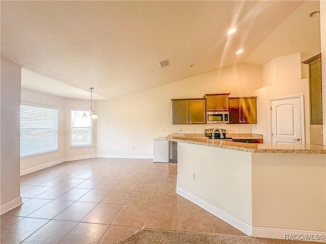 kitchen with light tile patterned flooring, stainless steel appliances, brown cabinets, light stone countertops, and decorative light fixtures